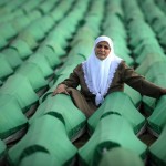 A Bosnian woman mourns over coffins of a