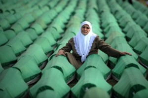 A Bosnian woman mourns over coffins of a