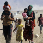 Displaced people from the minority Yazidi sect, fleeing violence from forces loyal to the Islamic State in Sinjar town, walk towards the Syrian border, on the outskirts of Sinjar mountain, near the Syrian border town of Elierbeh of Al-Hasakah Governorate August 11, 2014. Islamic State militants have killed at least 500 members of Iraq's Yazidi ethnic minority during their offensive in the north, Iraq's human rights minister told Reuters on Sunday. The Islamic State, which has declared a caliphate in parts of Iraq and Syria, has prompted tens of thousands of Yazidis and Christians to flee for their lives during their push to within a 30-minute drive of the Kurdish regional capital Arbil. Picture taken August 11, 2014.      REUTERS/Rodi Said    (IRAQ - Tags: POLITICS CIVIL UNREST) CONFLICT)