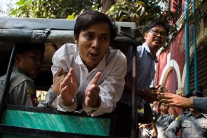 TOPSHOT - Detained Myanmar journalists Kyaw Soe Oo (C) and Wa Lone (R) talk to the media as is taken from a court in Yangon after making an appearance in his ongoing trial on February 14, 2018.
The court earlier denied bail to Wa Lone and Kyaw Soe Oo, two Reuters journalists charged under a secrecy act that could see them face up to 14 years in jail, in a case that has sparked outcry over shrinking media freedom. / AFP PHOTO / YE AUNG THU        (Photo credit should read YE AUNG THU/AFP/Getty Images)